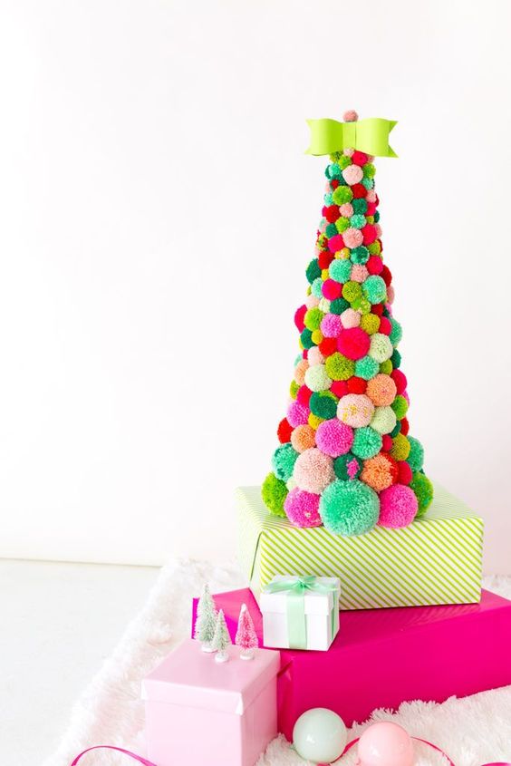 a colorful pompom Christmas tree of a large size with a green bow on top is a fun and old idea