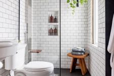 a contemporary bathroom with penny and subway tiles, built-in shelves, a sink and a wooden stool
