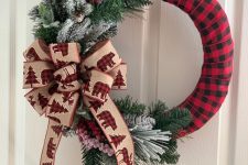 a cool Christmas wreath wrapped in plaid, with flocked and usual fir branches and a large bow with plaid bears is amazing