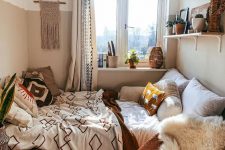 a cozy boho bedroom wiht a bed, a shelf with decor, a chair with faux fur and a pouf plus a lot of boho decor