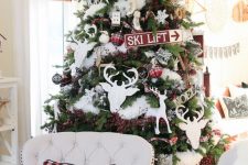 a cozy rustic Christmas tree with white fur, deep ornaments, plaid ones, snowflakes, branches with berries is a great idea