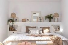 a cozy small boho bedroom with a ledge with decor and lamps, a bed with neutral bedding, built-in nightstands and a printed rug