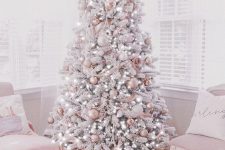 a delicate and refined glam Christmas tree with white and pink ornaments, with lights, flowers and ribbons is just jaw-dropping