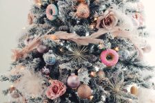 a glam and fun Christmas tree with pink feathers, pink, blue and gold ornaments, blooms and donut ornaments is all fun