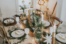 a glam rustic Christmas table setting with greenery, vine placemats, candles, stars, candles in candleholders is wow