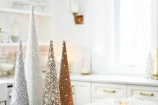 a gold tray with embellished and beaded cone Christmas trees and candles will compose a beautiful winter arrangement