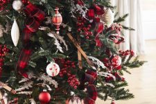 a gorgeous Christmas tree decorated with skis, red and white ornaments, plaid ribbons, berries and with red and white gifts under it