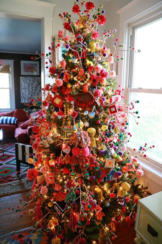 a granny chic Christmas tree with lights, ornaments and colorful pompoms on branches is a bold idea