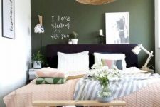 a small bedroom with moody green accent wall