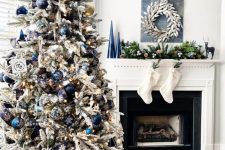a lovely flocked Christmas tree with blue and navy ornaments, lights, silver and gold ornaments and painted ones just wows