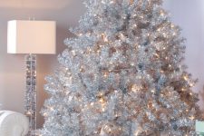 a luxurious silver Christmas tree with only lights and stacks of gift boxes is a lovely and very glam idea for any space