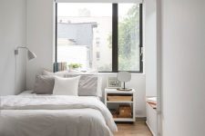 a minimal bedroom with a daybed, a bed with neutral bedding, a nightstand, a bench and a sconce is welcoming