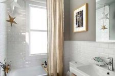 a minimal neutral bathroom with grey walls and printed tiles, a tub, a floating vanity, a mirror and a curtain