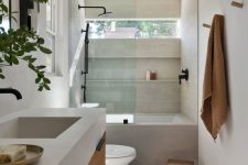 a minimalist bathroom with a window, a bathtub with a shower, a floating vanity and a stone countertop and a stool