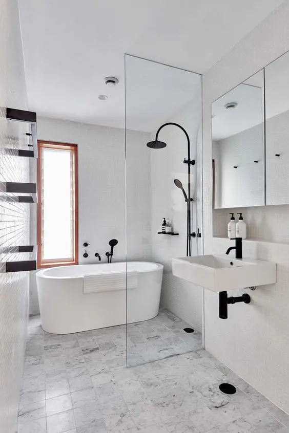 a modern bathroom with white and black and white tiles, an oval tub, a sink, a mirror cabinet and black fixtures