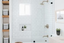 a modern bathroom with white subway and black printed tiles, a vanity with a sink, a niche with shelves and a stool