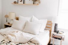 a neutral boho bedroom with a bed, nightstands, a ledge with decor and some printed bedding is cool and inviting