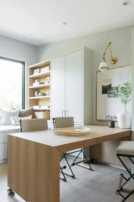 a neutral organic home office in dove grey, with a large wooden desk, a cupboard and a storage unit and a window daybed