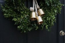 a pretty and simple Christmas wreath of greenery and gold bells on rope is a lovely and chic idea with a vintage feel