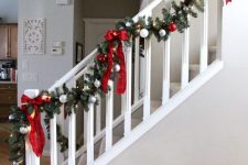 a pretty fir garland with silver and red ornaments, lights and plaid bows is a lovely and bold decor idea for Christmas