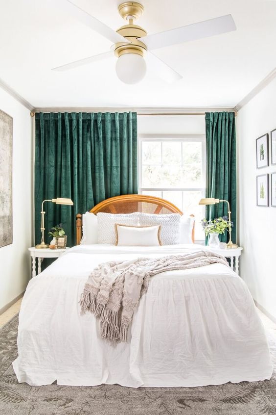 a refined small bedroom with a bed with a can headboard and neutral bedding, elegant nightstands and lamps and amazing green curtains