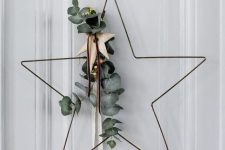 a refined star-shaped wreath with eucalyptus, a wooden star and leather cords is a nice alternative to a usual Christmas wreath