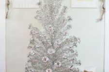 a silver Christmas tree with white faux fur, no decor and stacks of gift boxes in gold is a very shiny and cool modern idea
