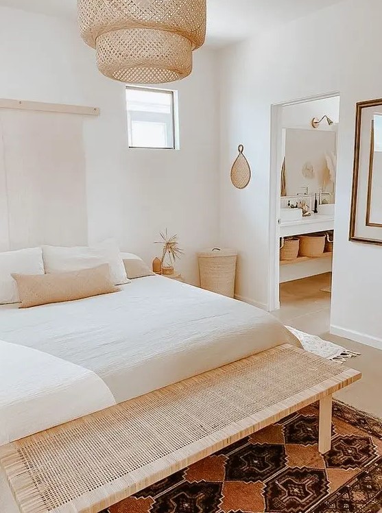 a small bedroom looks larger thanks to the neutral color scheme and wicker and woven pieces that are added for decor