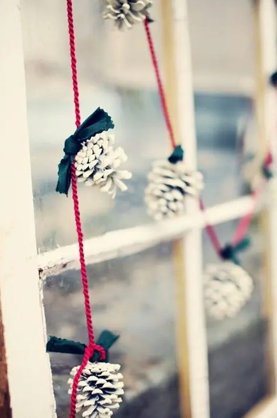 a snowy pinecone and bow garland in black, white and red is a cool decoration for a Christmas space