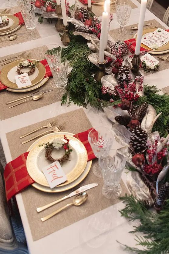 a traditional tablescape with red touches, pinecones, candles and evergreens for those who love classics