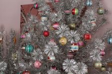 a vintage silver Christmas tree with bold vintage ornaments is a lovely and bright idea for vintage fans and it looks amazing
