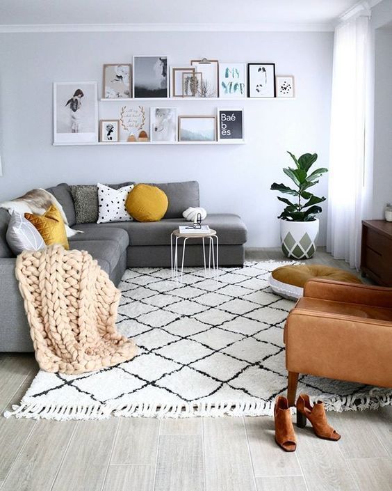 a welcoming monochromatic Scandi living room with a touch of color - a camel leather chair and mustard pillows