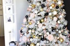 a white Christmas tree with striped, gold, polka dot and pink and silver ornaments plus blooms looks really glam-like