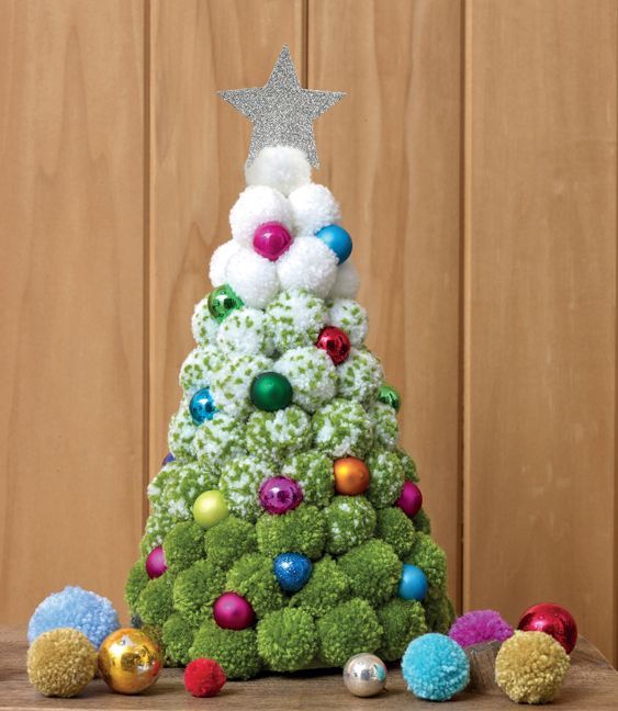 an ombre white to green pompom Christmas tree with colorful ornaments and a pretty silver glitter topper is a cool idea
