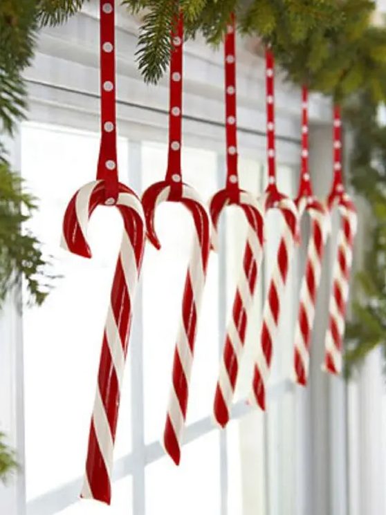 candy canes hanging from an evergreen garland are ideal for holidays