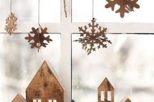 cardboard snowflakes hanging on the window, matching houses on the mantel will make your space Christmassy