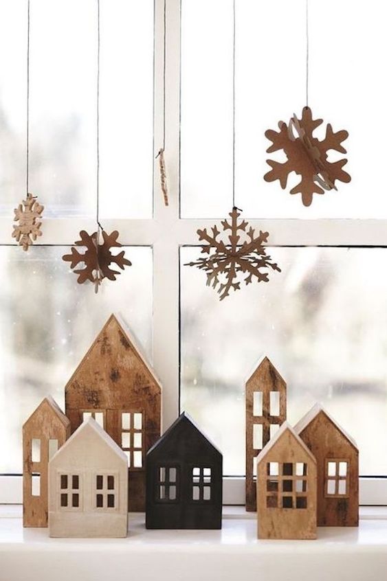 cardboard snowflakes hanging on the window, matching houses on the mantel will make your space Christmassy