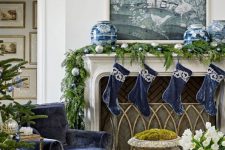 chic Christmas decor with navy and white stockings chinoiserie vases, a garland with silver and blue ornaments