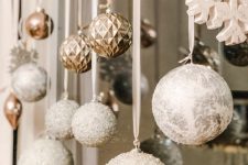 copper, silver glitter and snowflake ornaments hanging down the window are great to style it for the holidays