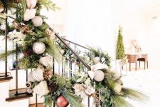 elegant vintage railing decor with fir branches, foliage, neutral and metallic ornaments, ribbons and bows is ideal for winter