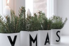 fir branches in white pots and white candles will be amazing for windowsill or console table decor with a Scandinavian feel