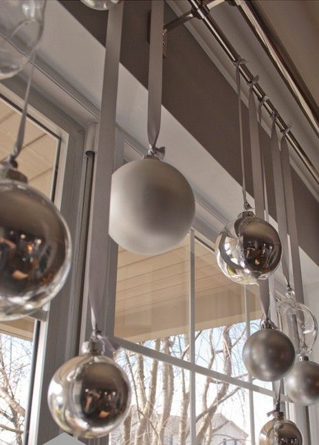 hang silver and white Christmas ornaments on the window to make it feel like holidays