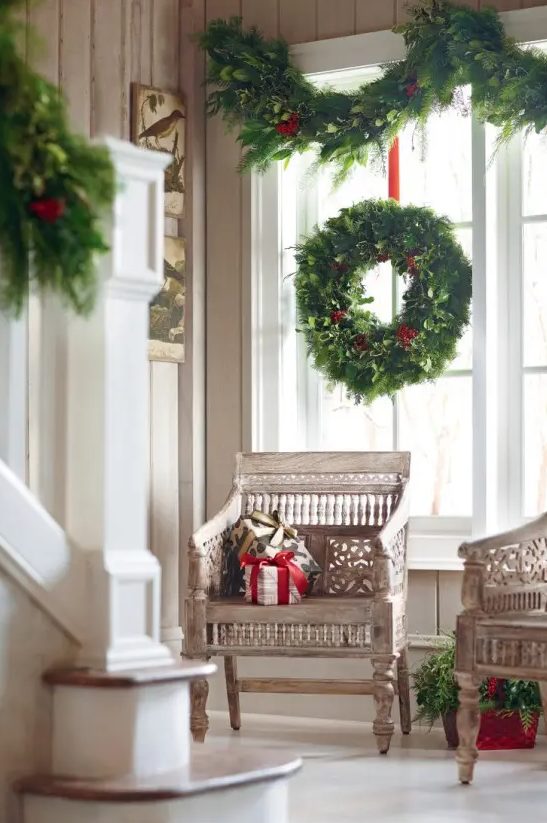 lush evergreen wreaths and garlands are a timeless option that fits any interior, they will make your window Christmassy