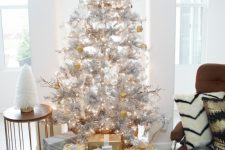 metallic decor ideas – a silver Christmas tree with gold and white ornaments and gift boxes wrapped with gold and silver