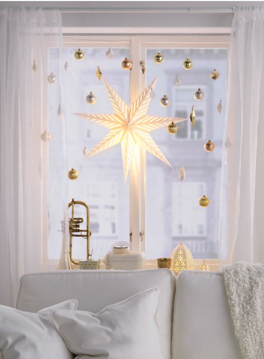 metallic ornaments and a star lantern hanging on the window give a chic and glam look to the space in winter