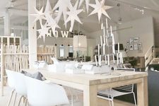 oversized white lasercut stars hanging over the table and an advent candelabra for a real Nordic feel in the space