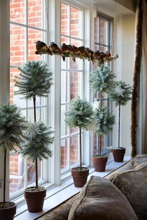 potted mini trees and a branch with lots of birds for creative and very chic Christmas window decor