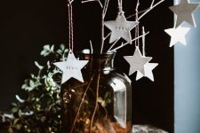 pretty Christmas decor with a large apothecary bottle with branches, white clay star ornaments is a lovely and easy idea