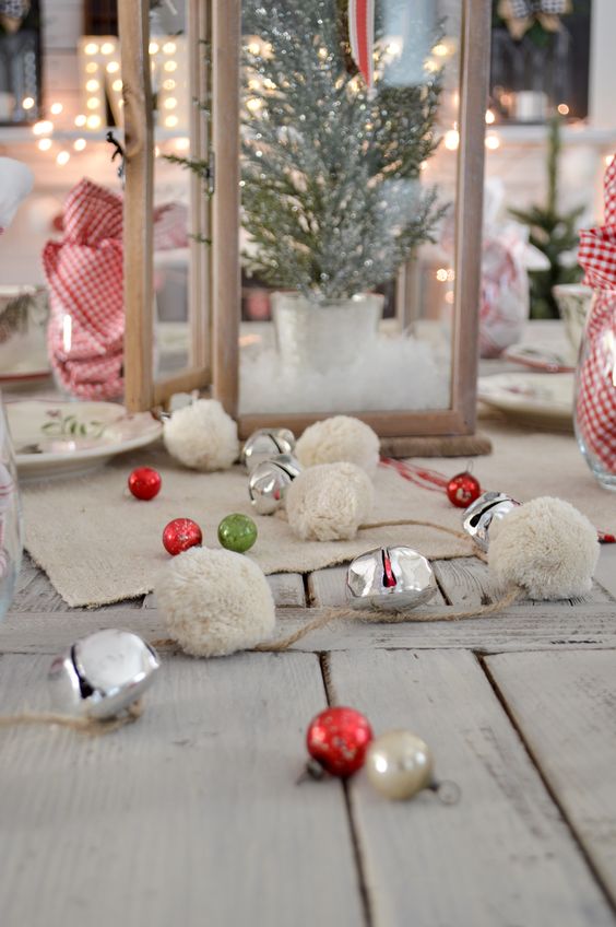 pretty rustic Christmas decor with red, gold and green ornaments and white pompoms plus bells is lovely