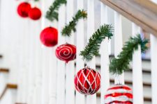 red and silver ornaments hanging on tiny evergreen twigs attached to the railing will delicately and chic decorate the space